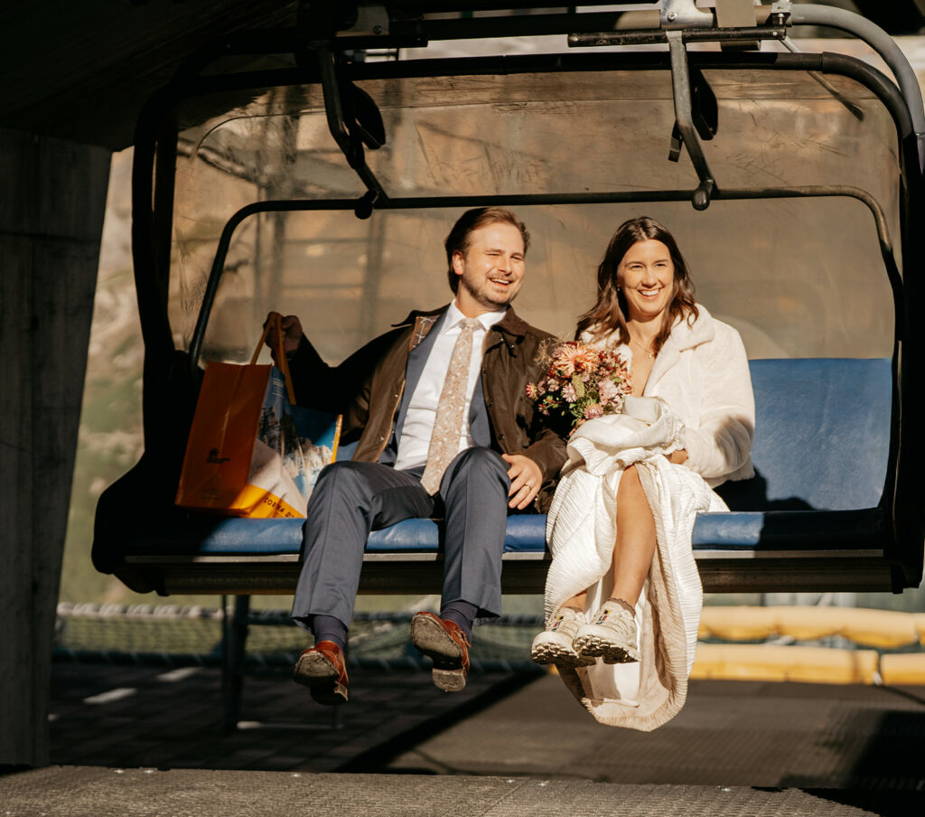 Bride and groom on ski lift with flowers