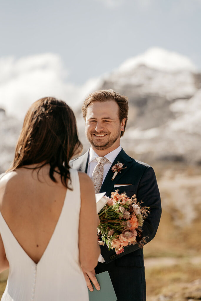 Couple exchanging vows in scenic mountain setting.