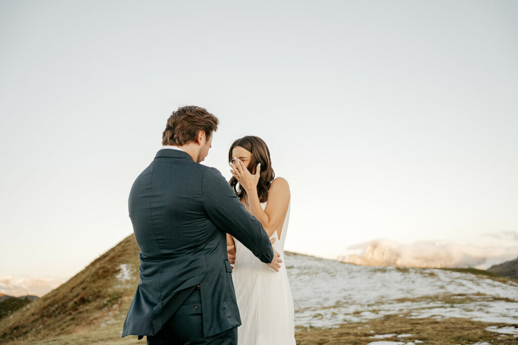 Couple smiling during outdoor ceremony in mountains.