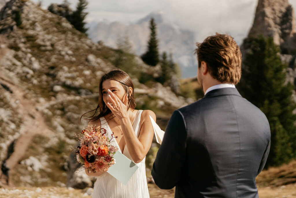 Emotional couple exchanging vows in mountain setting.