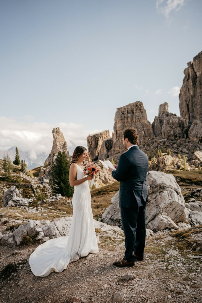 Couple exchanging vows in mountain landscape.