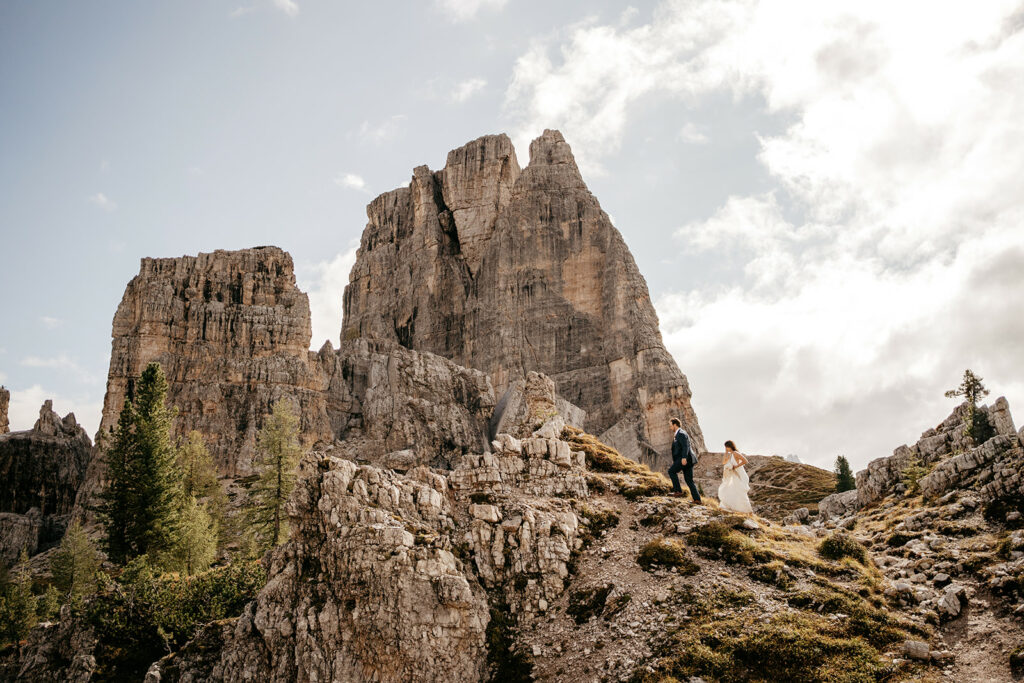 Couple hiking by dramatic mountain scenery.