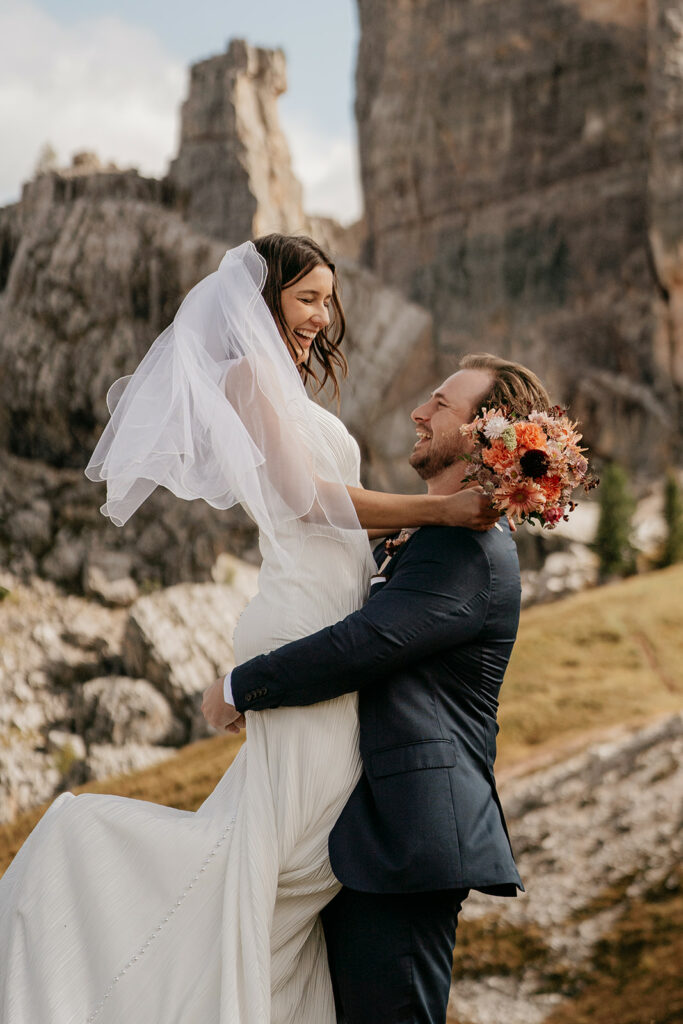 Bride and groom smiling in mountain landscape