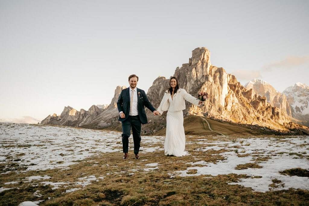 Couple walking in mountain landscape during wedding.