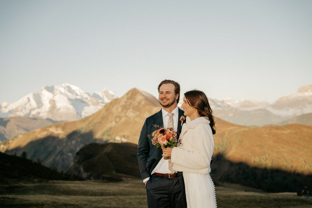 Couple smiling in mountain landscape with bouquets