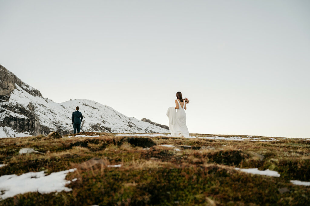 Bride and groom in snowy mountain landscape