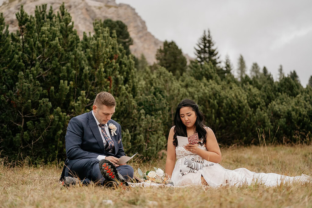 Couple reading outdoors during intimate wedding ceremony