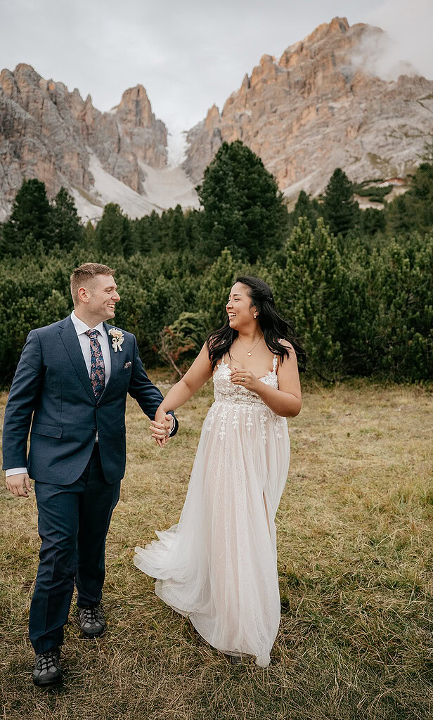 Smiling couple holding hands near mountains