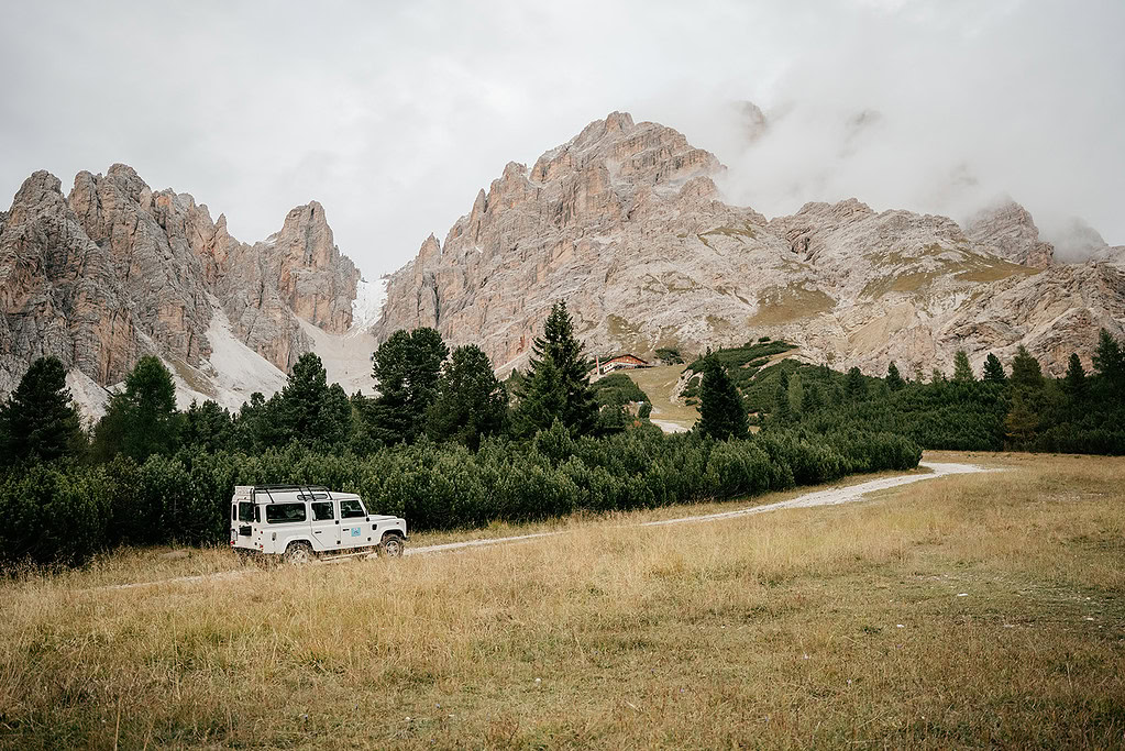 SUV on mountain path with alpine backdrop