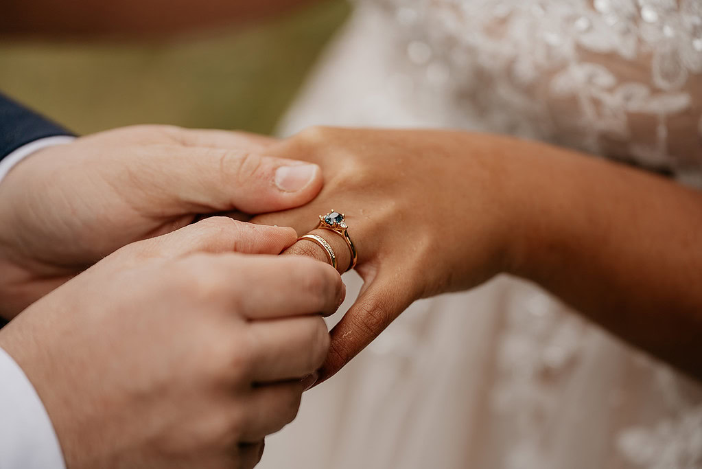 Wedding ring exchange close-up, groom's hands shown