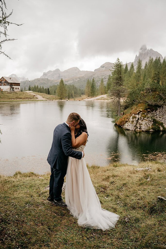 Couple kissing by a picturesque mountain lake.