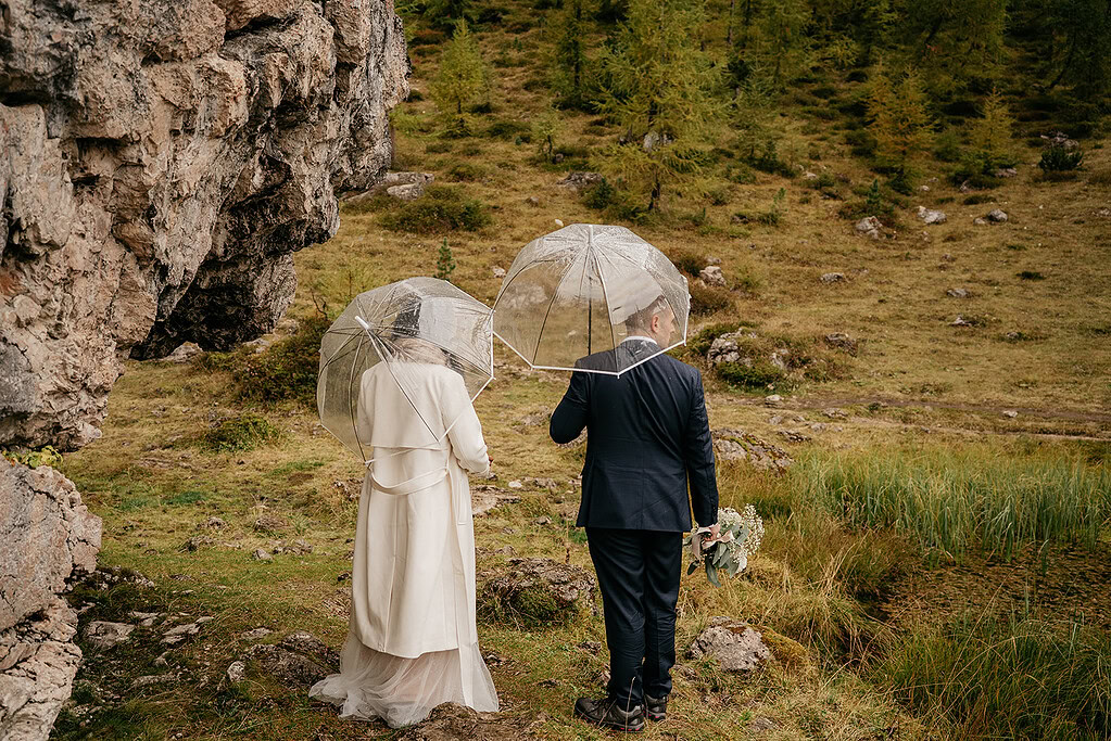 Couple with umbrellas in rocky landscape