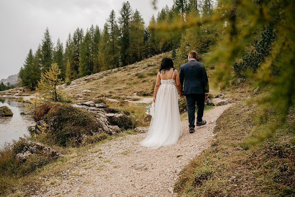 Couple walking on forest path in wedding attire