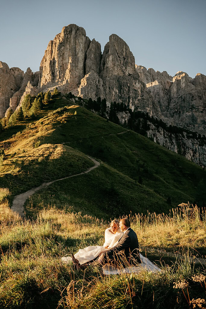 Couple sitting on hillside with mountain view
