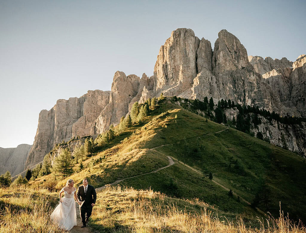 Bride and groom hiking in mountain landscape