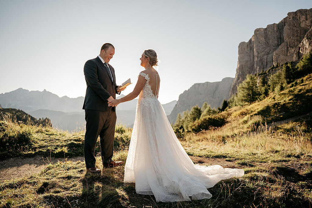 Couple exchanging vows in mountain setting.