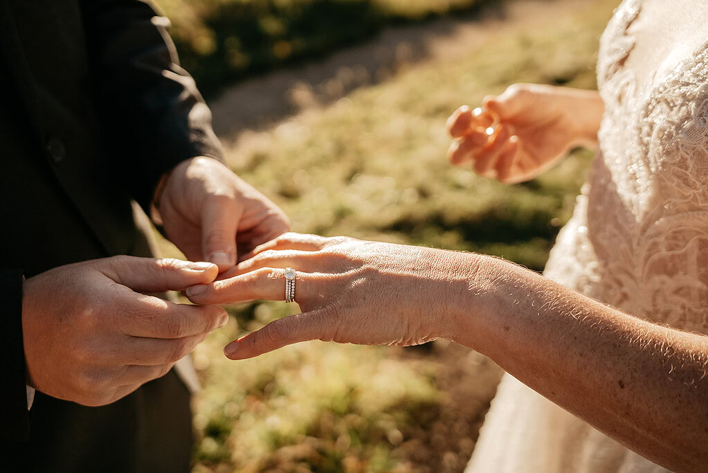Couple exchanging wedding rings outdoors