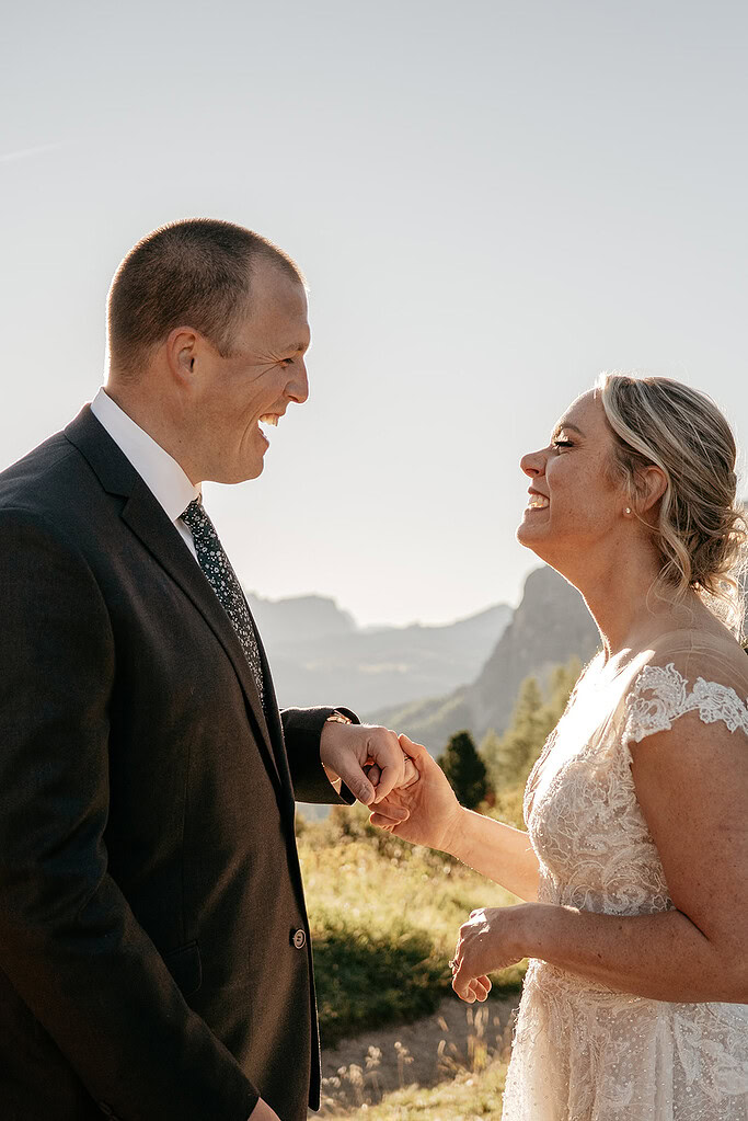 Smiling couple holding hands outdoors at wedding